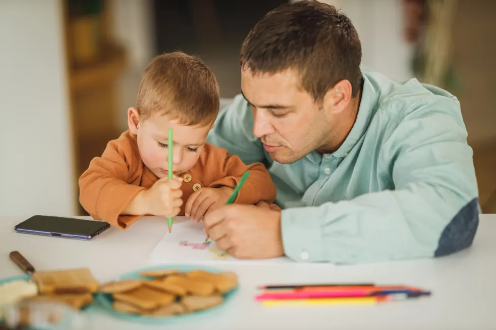 Padre e hijo dibujando tranquilos en casa